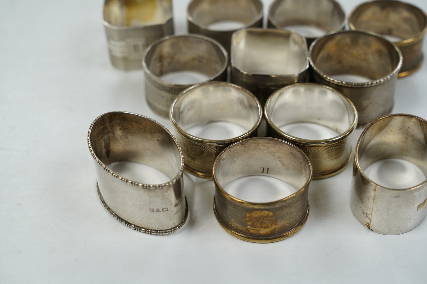 Eight assorted silver napkin rings, including a pair, Birmingham, 1937 and four plated napkin rings. Condition - fair